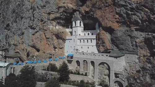 Aerial view of The Monastery of Ostrog, Serbian Orthodox Church situated against a vertical background, high up in the large rock of Ostroška Greda, Montenegro. Dedicated to Saint Basil of Ostrog 