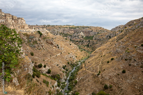 View of Gravina river canyon and park of the Rupestrian Churches of Matera with houses in caves di Murgia Timone near ancient town Matera (Sassi), , Basilicata, Italy