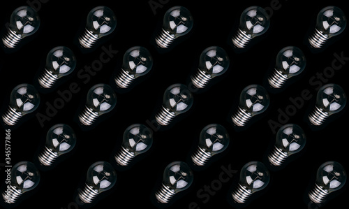 Pattern light bulbs on a black background, concept of lack of new ideas