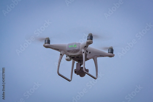 Drone is flying with digital camera to take photo and video on ground at sunset time.