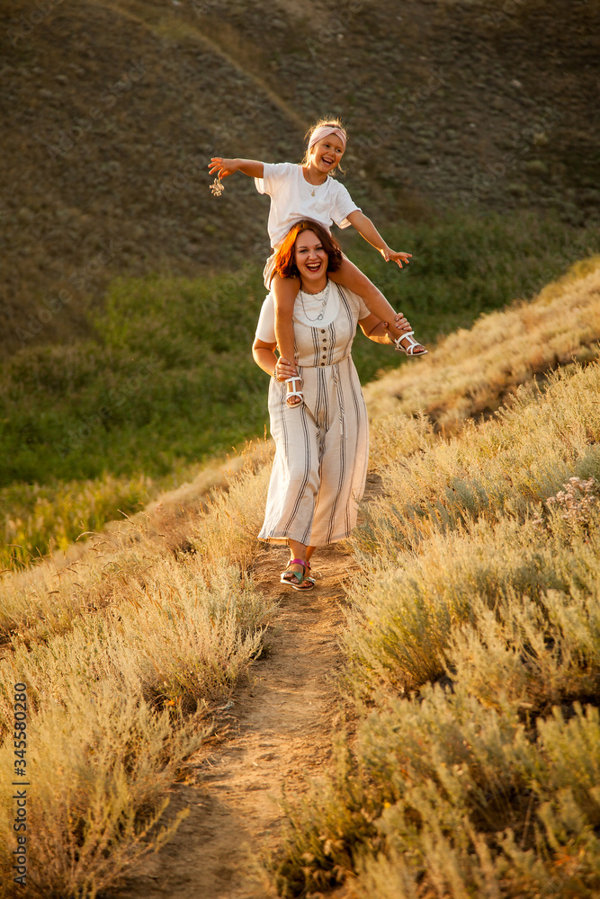 Happy mother and daugther enjoiyng in field in sunny day Happy mother and daugther enjoiyng in field in sunny day