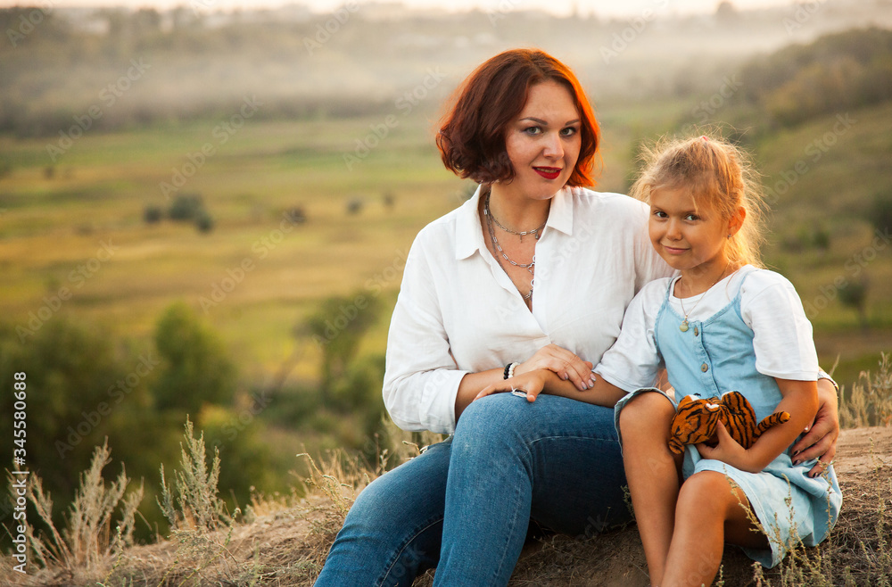 Happy mother and daugther enjoiyng in field in sunny day Happy mother and daugther enjoiyng in field in sunny day