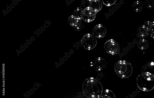transparent bubbles floating on the dark with copy space, bubbles abstract background, on black background