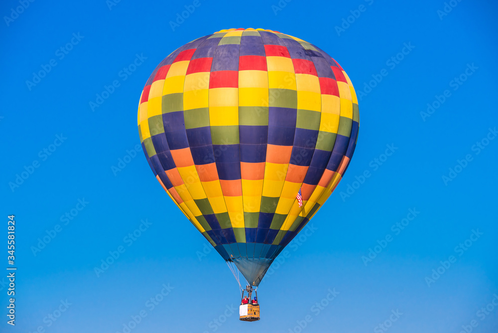 Naklejka premium Close up hot air balloon flying up on cosmos field with blue sky background