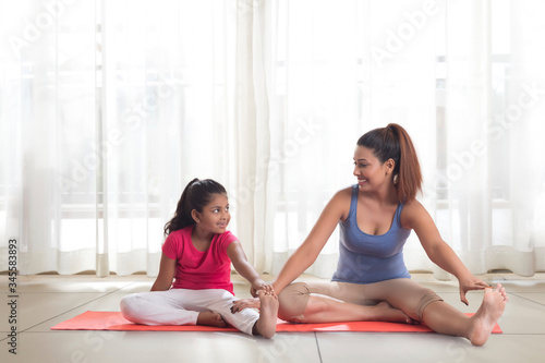Mother teaching exercise to her daughter 