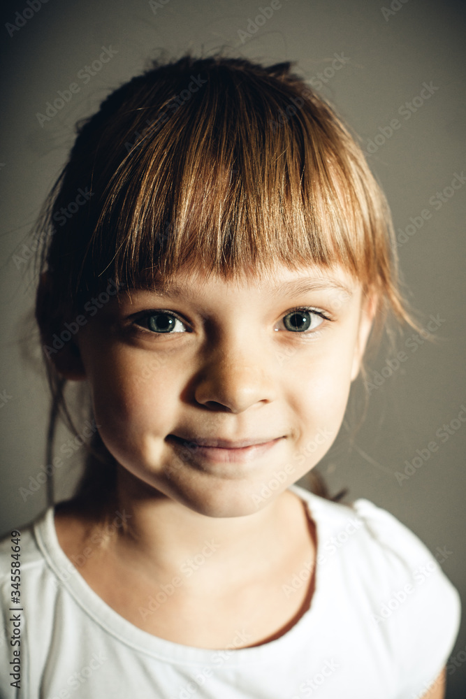 beautiful and cute little girl on a gray background close-up beautiful and cute little girl on a gray background close-up