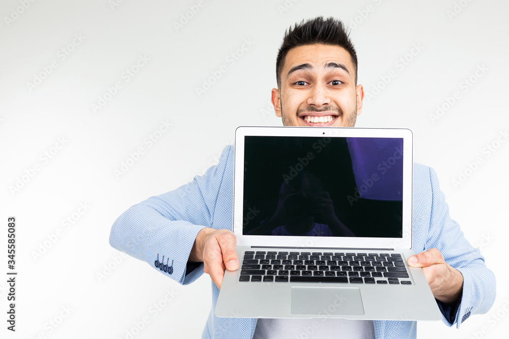 stylish successful man in a jacket demonstrates a laptop screen with space for advertising on a white studio background with copy space stylish successful man in a jacket demonstrates a laptop screen with space for advertising on a white studio background with copy space