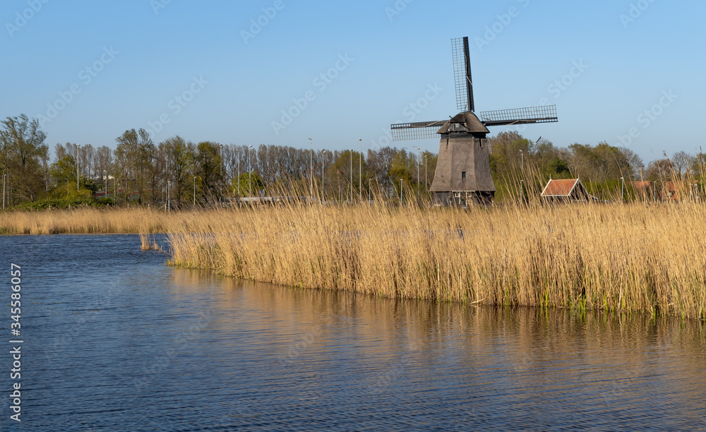 Tradycyjny, holenderski wiatrak nad kanałem wodnym, Alkmaar w Holandii Północnej.