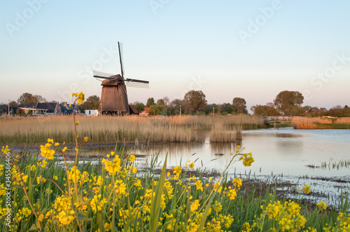 Holenderskie wiatraki nad kanałem wodnym, zachód słońca w Holandii Północnej © Bozena