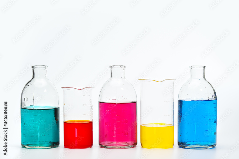 Glass bottles and flasks of different sizes with liquids of different colors on the background. Chemical lab. Glass bottles and flasks of different sizes with liquids of different colors on the background. Chemical lab.