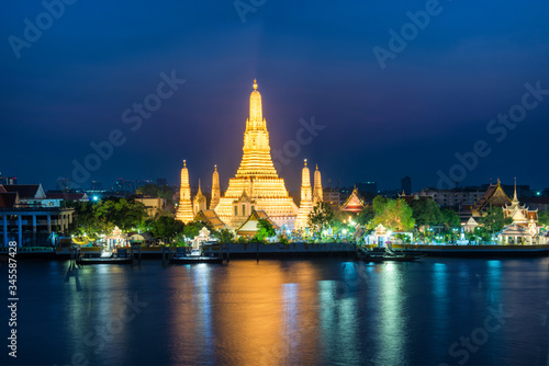 Night illuminated Temple of Dawn or Wat Arun and its reflection in Chao Phraya River at sunset. Bangkok  Thailand