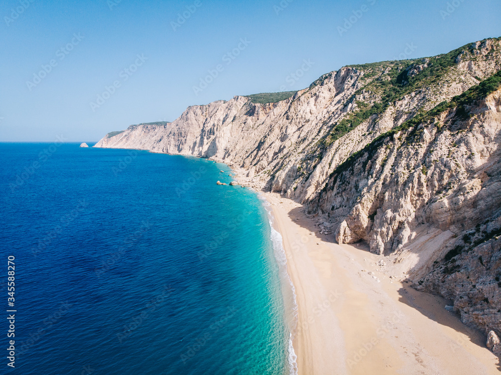 Aerial view of a clean white sandy beach on the shores of a beautiful turquoise sea. Greece.