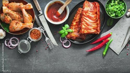 Various kinds of grill and bbq meats with vintage kitchen and butcher utensils. Chicken legs, steaks, pork ribs with herbs, spices, sauces and ingredients for grilling
