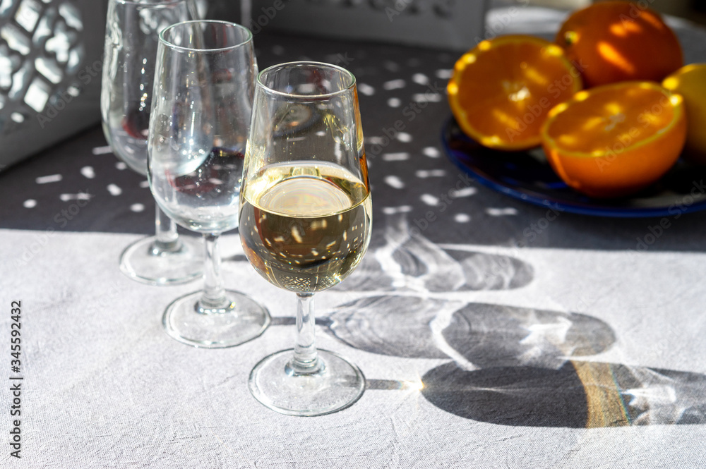 Obraz premium Glasses with cold fino sherry fortified wine and orange in sunlights, andalusian style interior on background