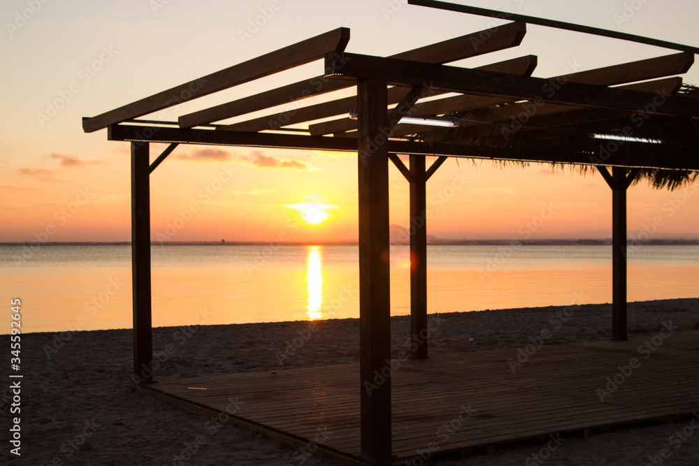 A view of a beach bar with a sunset back light
