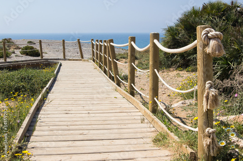 A wooden pathway towards the beach in a summer day
