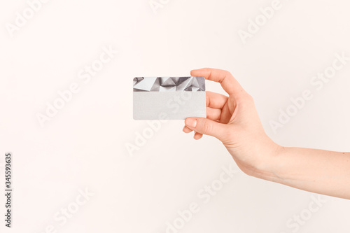 A beautiful female hand holds a Bank credit card with an online service, after completing the documents.