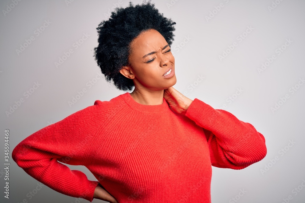 Young beautiful African American afro woman with curly hair wearing red casual sweater Suffering of neck ache injury, touching neck with hand, muscular pain Young beautiful African American afro woman with curly hair wearing red casual sweater Suffering of neck ache injury, touching neck with hand, muscular pain