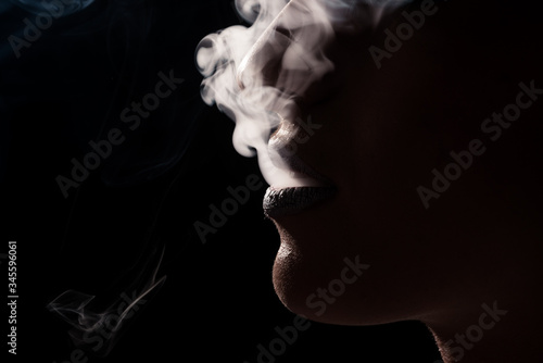 Close up mouth woman smoking cigarette with the smoke