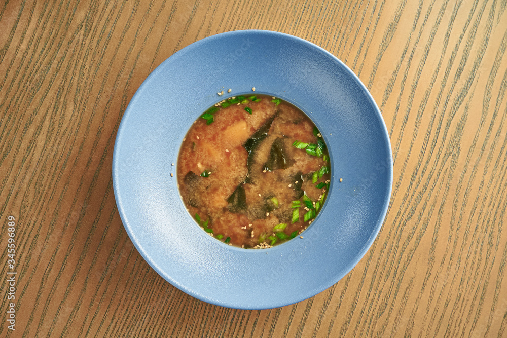 Traditional japanese miso soup in a blue bowl on a wooden background. Healthy, Dietary Food. Close up
