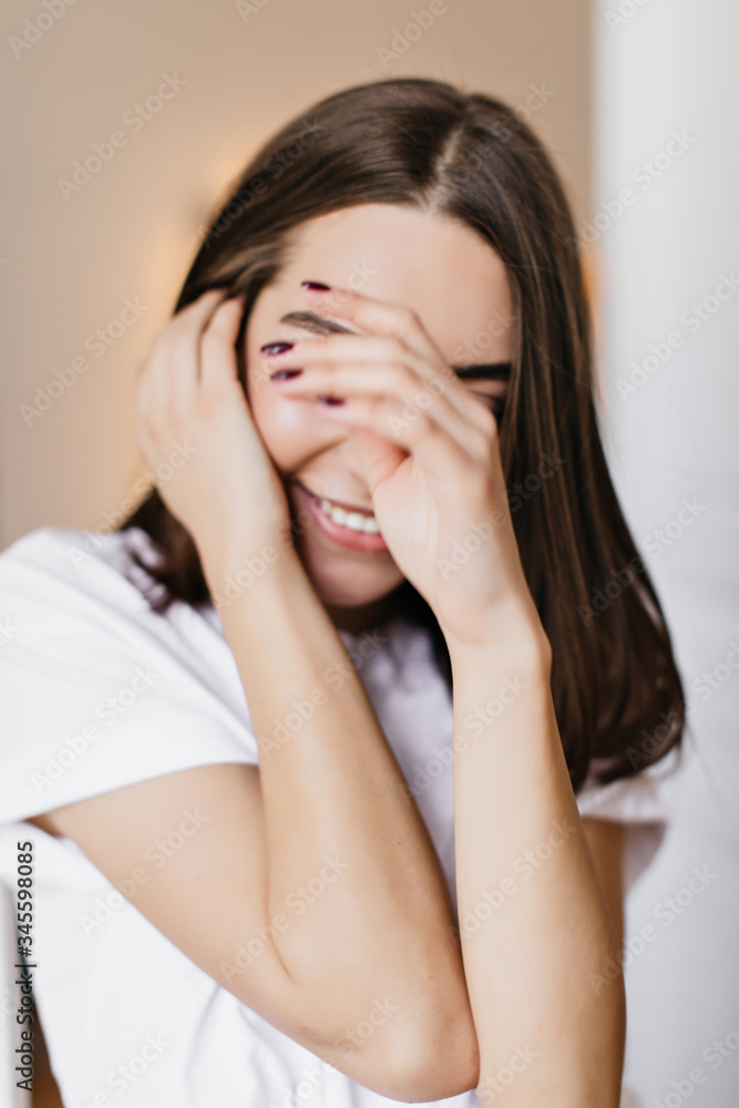 Close-up portrait of winsome brunette lady with trendy manicure. Indoor shot of attractive smiling girl covering eyes with hands. Close-up portrait of winsome brunette lady with trendy manicure. Indoor shot of attractive smiling girl covering eyes with hands.