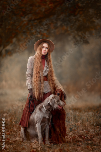 Photography Beautiful long-haired blonde young woman in English style with Irish setter and