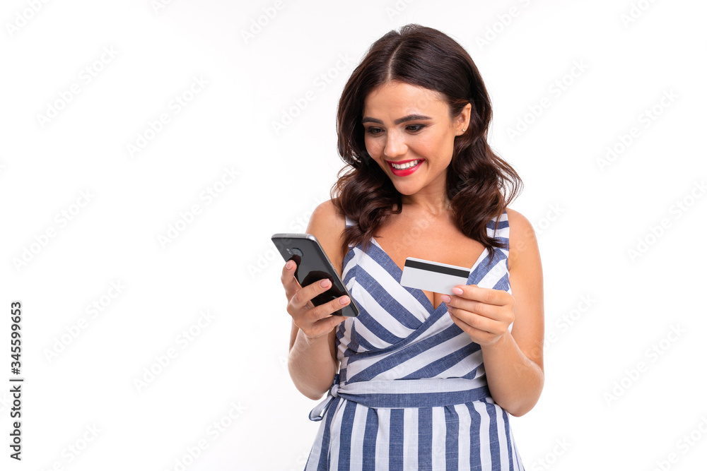 Portrait of nice caucasian girl holds a phone and credit card isolated on white background Portrait of nice caucasian girl holds a phone and credit card isolated on white background
