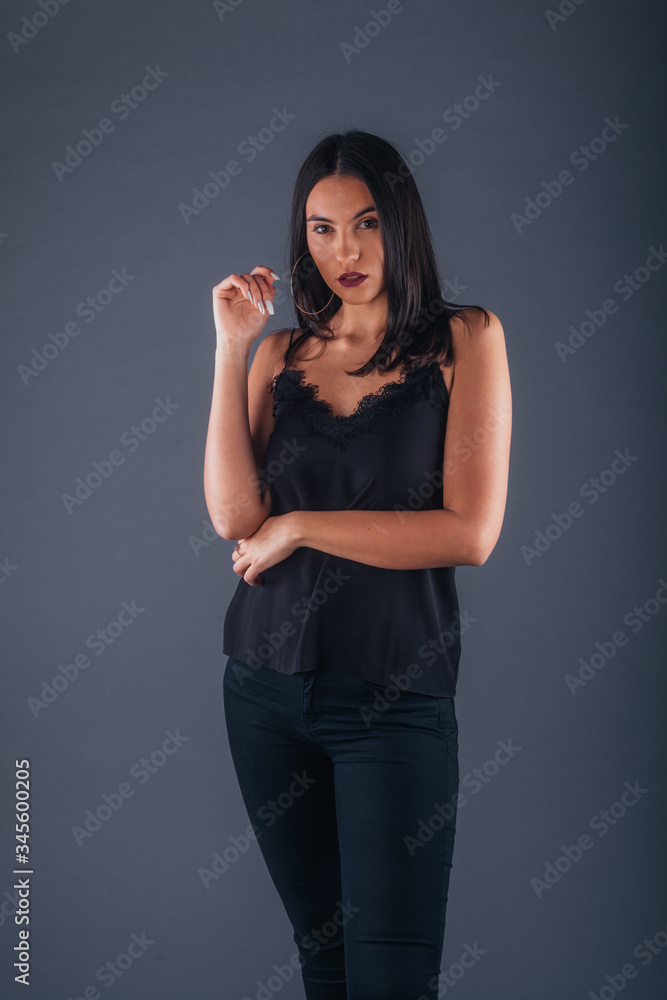 Sensual studio portrait of a sexy woman standing with one arm crossed on a gray background Sensual studio portrait of a sexy woman standing with one arm crossed on a gray background