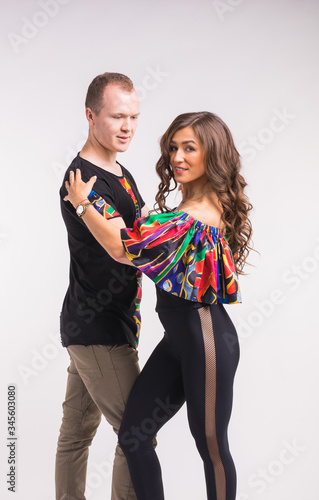 Funny couple dancing social dance. Kizomba or bachata or semba or taraxia , on white background. Social dance concept. photo