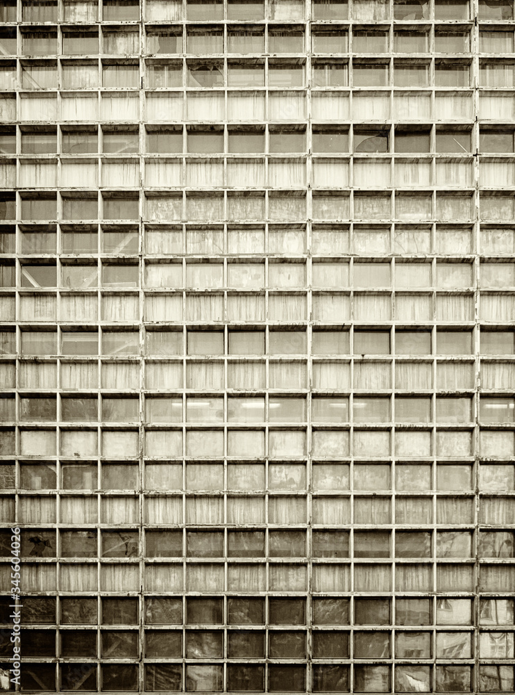 Street of the city. Large industrial factory building. The figure of a man walking on the background of the factory wall. Picture taken in Ukraine. Kiev region. Vertical frame. Sepia. Street of the city. Large industrial factory building. The figure of a man walking on the background of the factory wall. Picture taken in Ukraine. Kiev region. Vertical frame. Sepia.