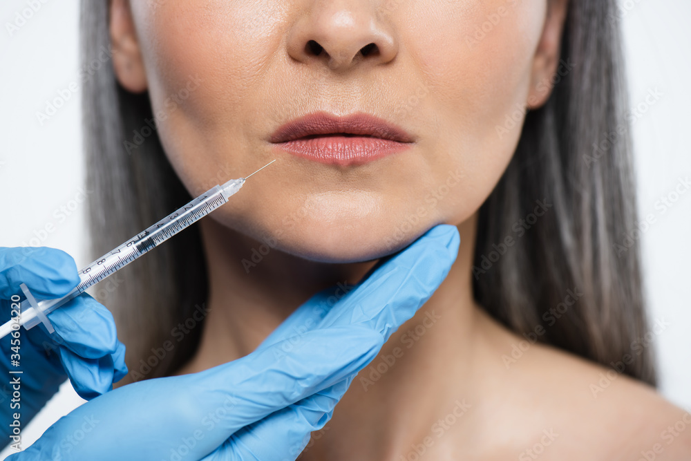cropped view of naked adult woman and doctor in latex gloves holding syringe with beauty injection isolated on grey cropped view of naked adult woman and doctor in latex gloves holding syringe with beauty injection isolated on grey