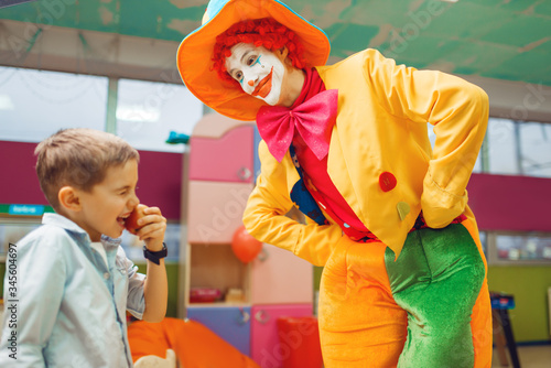Obraz na plátne Funny clown animator dancing with little boys