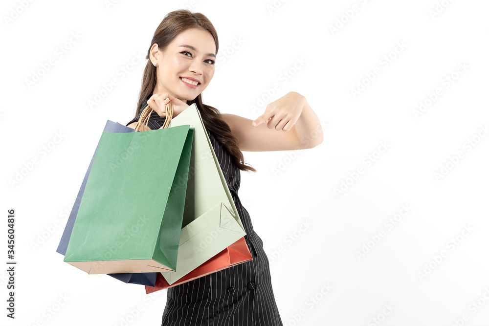 Portrait of young beautiful asian girl wearing black dress holding shopping bags and smile isolated over white background. Online shopping and black friday concept. Portrait of young beautiful asian girl wearing black dress holding shopping bags and smile isolated over white background. Online shopping and black friday concept.