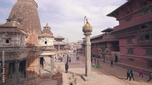 Narsingha Temple And King Yoganarendra Malla Bronze Statue Over The Stone Column. Patan Durbar Square, Kathmandu, Nepal. - wide to panning photo