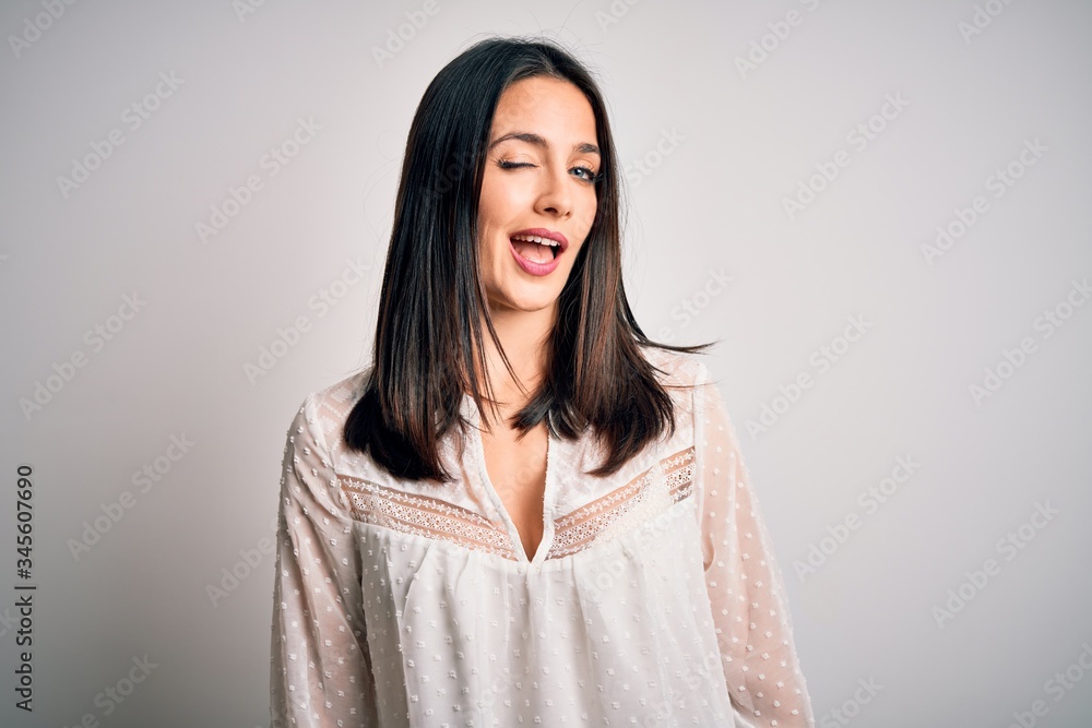 Young brunette woman with blue eyes wearing casual t-shirt over isolated white background winking looking at the camera with sexy expression, cheerful and happy face. Young brunette woman with blue eyes wearing casual t-shirt over isolated white background winking looking at the camera with sexy expression, cheerful and happy face.