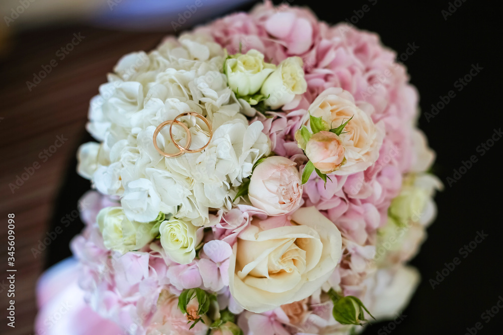close-up of the wedding round bouquet of the bride in delicate colors pink and white, hydrangea rose , gold wedding rings close-up of the wedding round bouquet of the bride in delicate colors pink and white, hydrangea rose , gold wedding rings