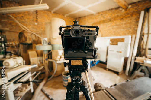 Camera set up on tripod recording production in carpentry
