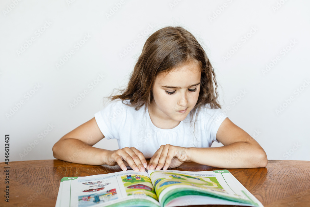 A school girl does homework at home, classes via the Internet, online, learning a foreign language, learning English, notebook, learn letters and words A school girl does homework at home, classes via the Internet, online, learning a foreign language, learning English, notebook, learn letters and words