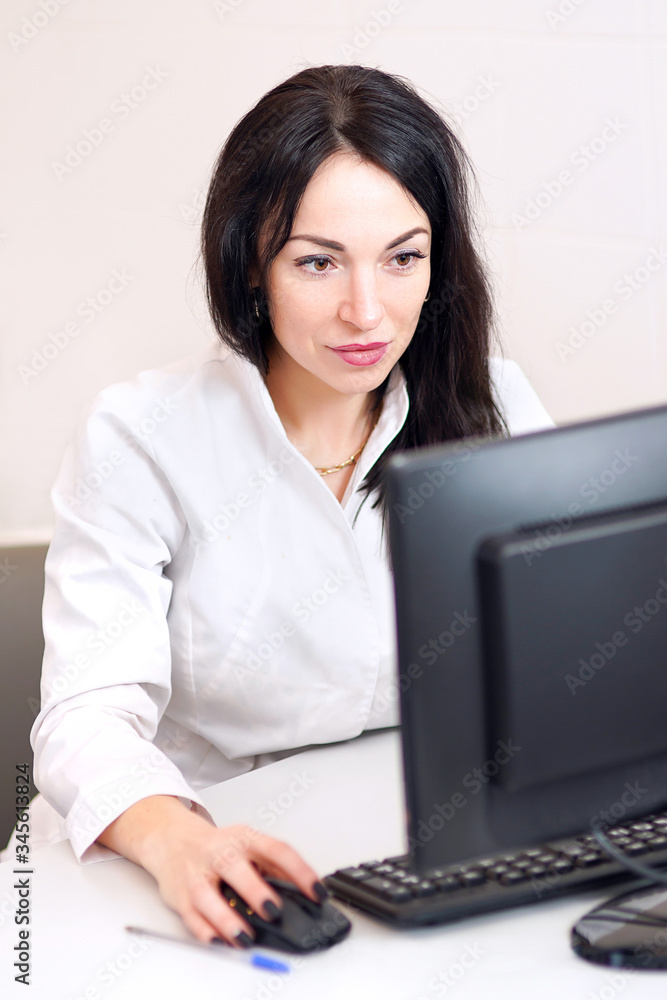 Searching for information. Dark-haired doctor in a white robe working on a computer looking thoughtful Searching for information. Dark-haired doctor in a white robe working on a computer looking thoughtful