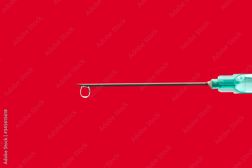 Medical syringe with a needle at the end of the drop. Medical syringe with a needle at the end of the drop.