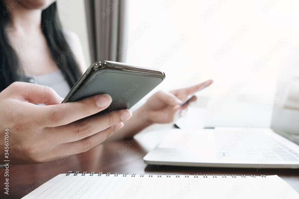 Fototapeta premium Online payment.woman's hands holding smartphone and using credit card for online shopping. Cyber Monday Concept