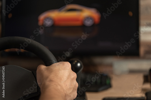 Hand holding a toy steering wheel for playing car simulator. Computer games. Entertainments
