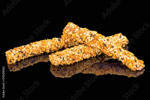 Tasty breadsticks grissini with fagopyrum seeds with reflection, isolated on black background. 