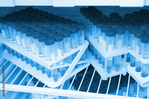 transparent flasks with blue caps with chemicals in the refrigerator in the laboratory in blue light