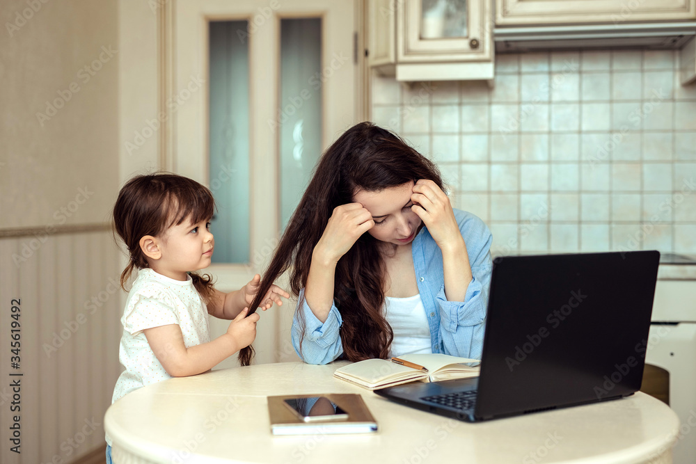 upset tired woman freelancing at home with small child upset tired woman freelancing at home with small child