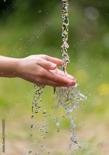 公園で水道水を使って手を洗う子供