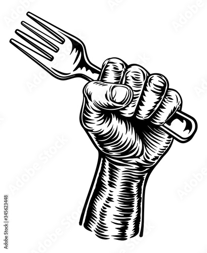 A fist hand holding a fork in a vintage intaglio woodcut engraved or retro propaganda style