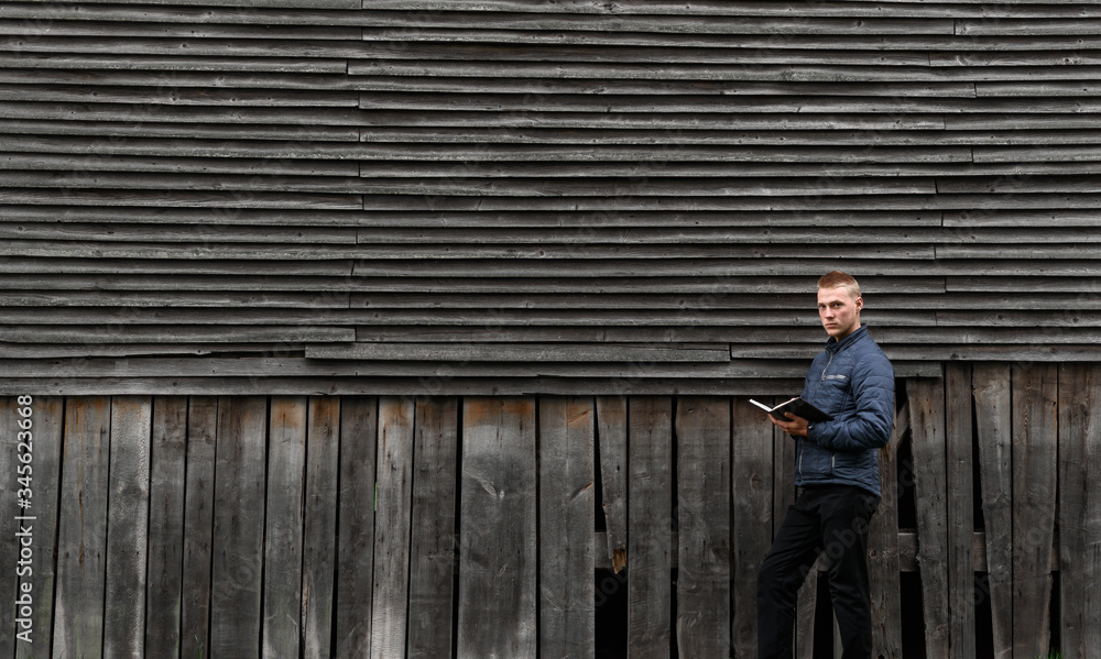 Fototapeta premium man standing on a wooden fence
