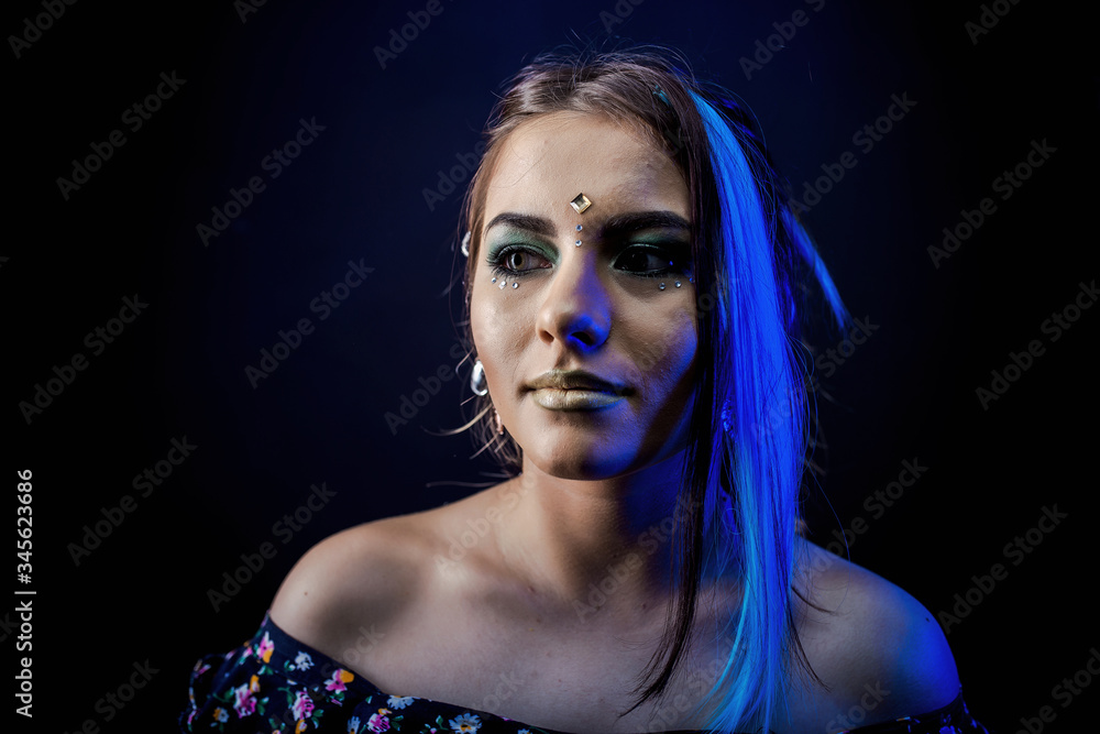 ethnic girl on a black background in blue light