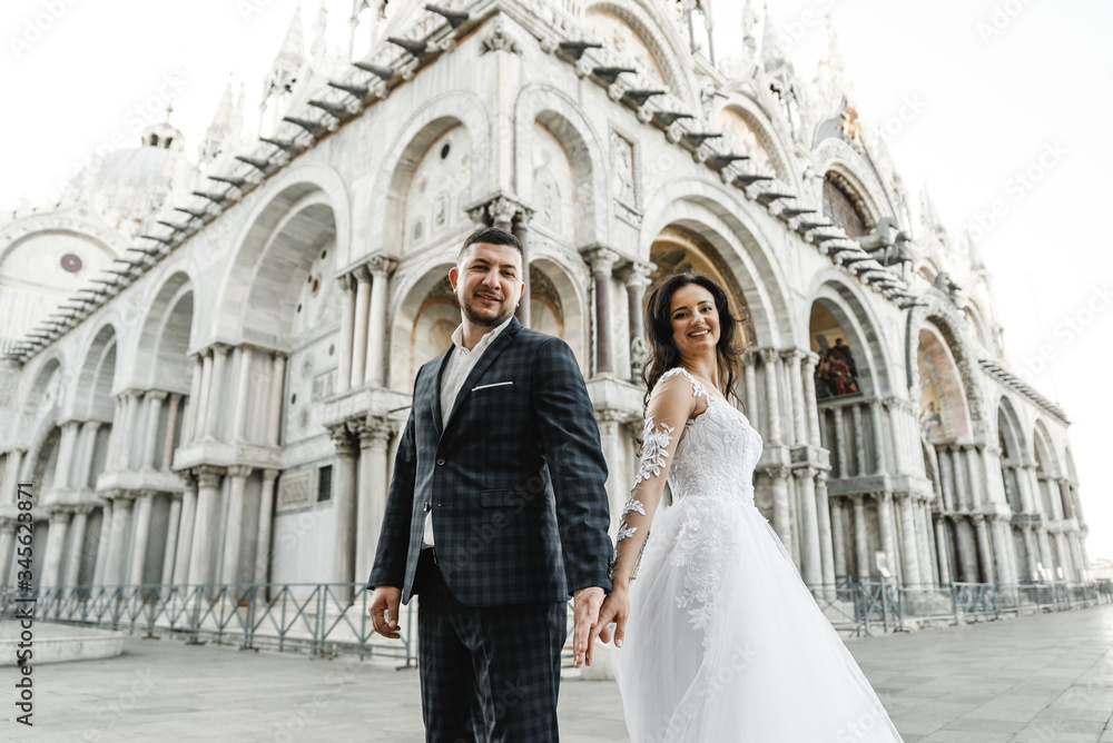 bride and groom on the background of a historic building,bride and groom walk the streets of the old city of venice,newlyweds dance,european wedding,quarantine wedding